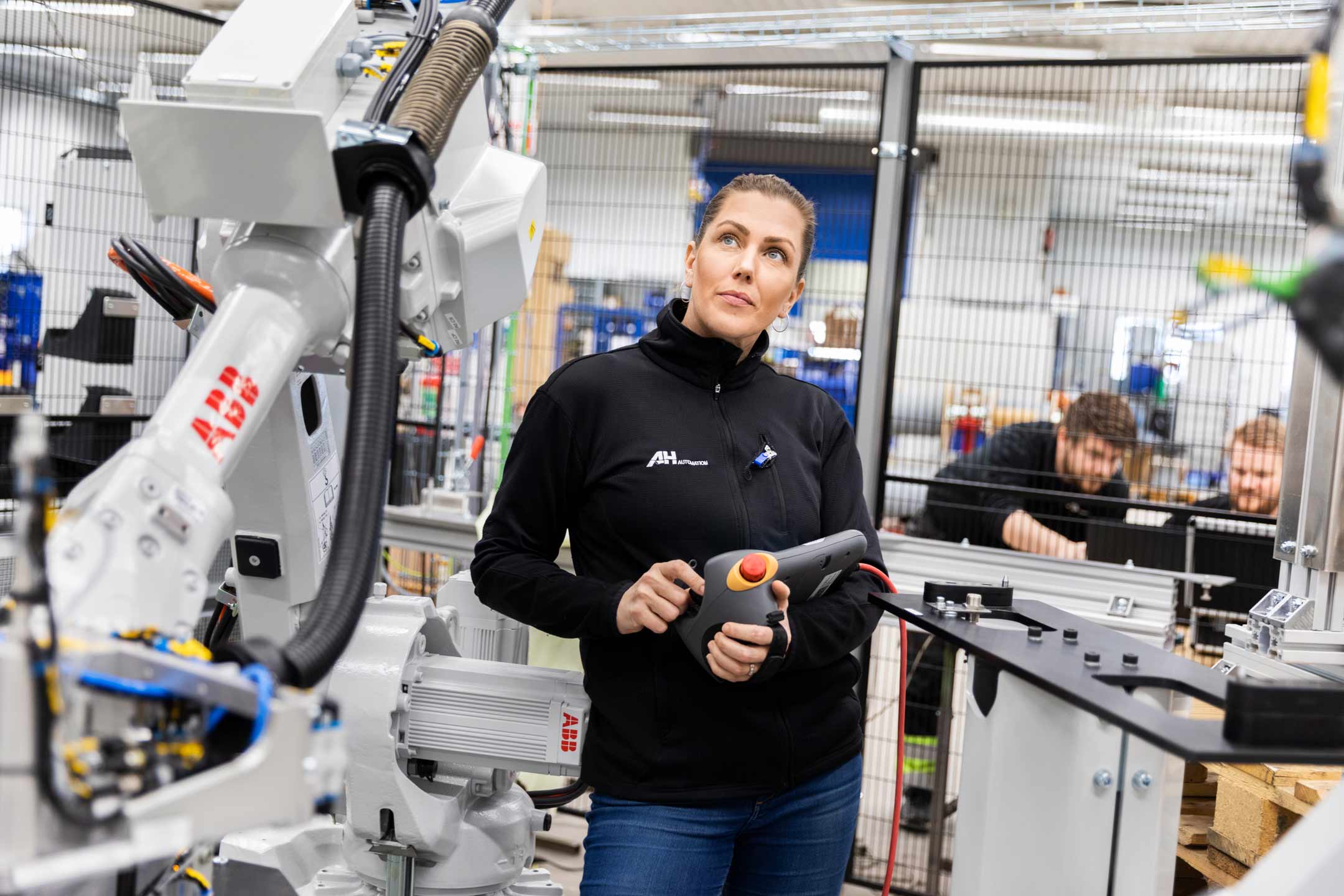 Kvinna kontrollerar robotcell